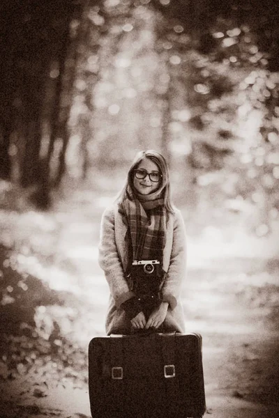 Flicka med suicase i en park — Stockfoto