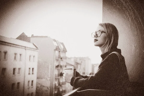 Chica con taza sentada en el balcón — Foto de Stock