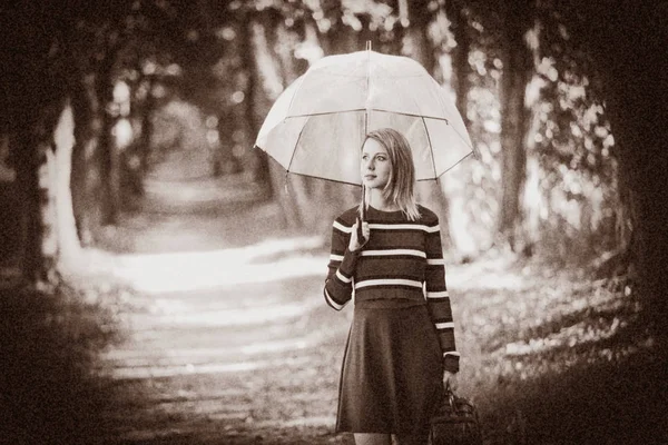 Fată cu umbrelă și valiză în parcul de toamnă — Fotografie, imagine de stoc