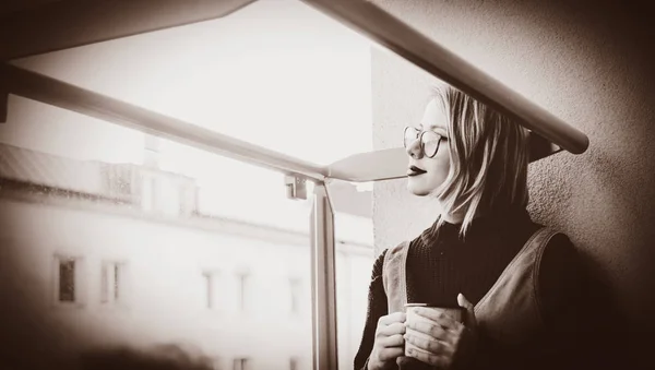 Girl with cup sitting at balcony — Stock Photo, Image