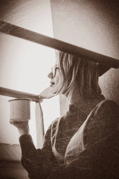 バルコニーに座ってカップを持つ少女 — ストック写真