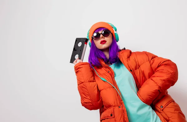 Menina com cabelo roxo com fones de ouvido e VHS — Fotografia de Stock