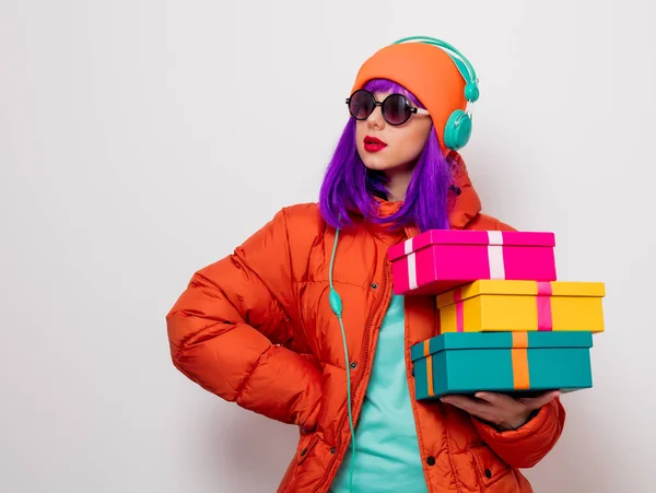 Девушка с фиолетовыми волосами с наушниками и подарками — стоковое фото