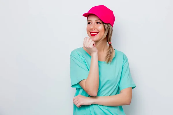 ピンクの帽子と白い背景の青い シャツの美しい少女 — ストック写真