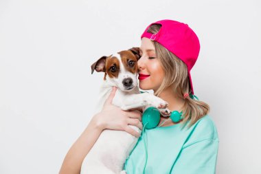 Güzel genç kız pembe kap ve Jack Russell Terrier köpek beyaz zemin üzerine mavi tişört.