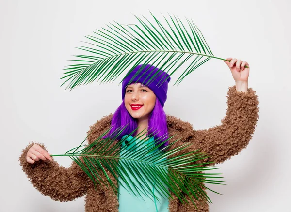美丽的年轻女孩与紫色头发在夹克与棕榈叶子在白色背景 — 图库照片