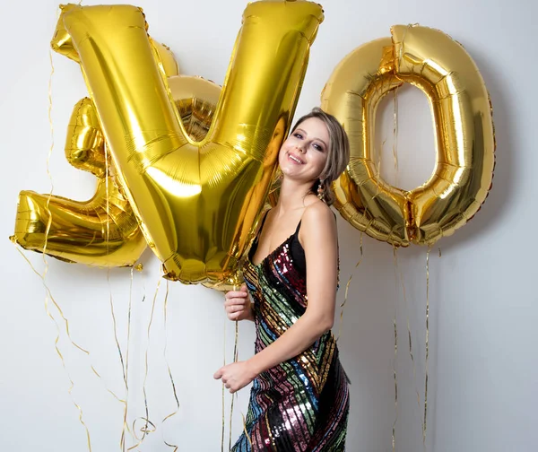 彼女の 歳の誕生日にゴールデンの風船を持つ若い女性 屋内の場所 ビンテージ ドレスと髪型 白い背景の上 — ストック写真