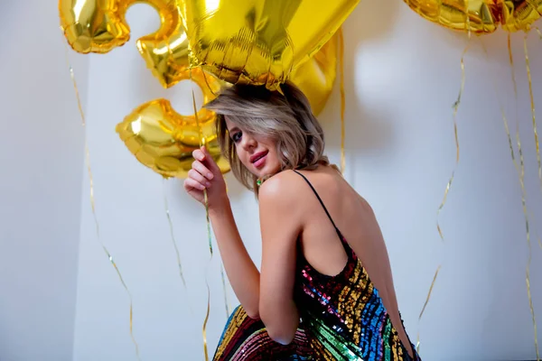 彼女の 歳の誕生日にゴールデンの風船を持つ若い女性 屋内の場所 ビンテージ ドレスと髪型 白い背景の上 — ストック写真