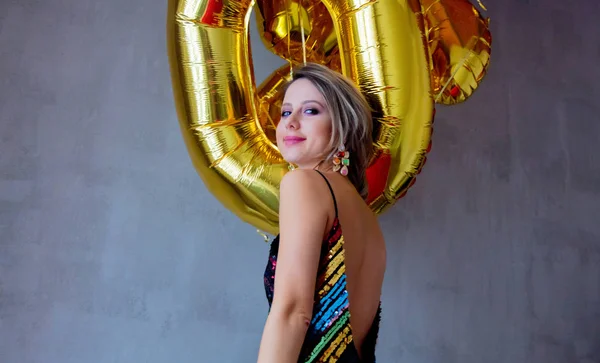 在她三十岁生日的时候 拿着金色气球的年轻女子 室内位置 人是在老式的80年代礼服和发型 在灰色背景上 — 图库照片