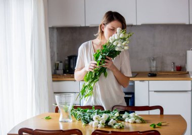 Kız ipreparing bunları vazoya koymadan önce beyaz gül buketi