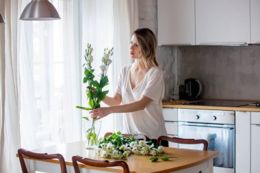 Kız ipreparing bunları vazoya koymadan önce beyaz gül buketi