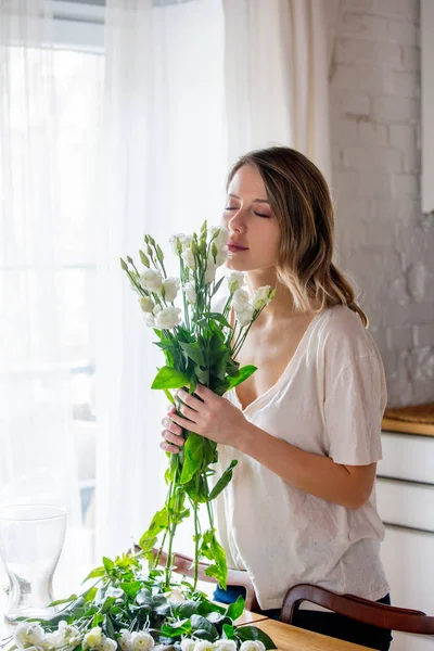 Chica ipreparing un ramo de rosas blancas antes de ponerlos en un jarrón —  Fotos de Stock