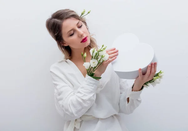 Mulher com rosas brancas segurando uma caixa de presente em forma de coração . — Fotografia de Stock