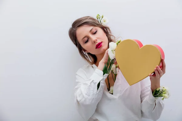 Nő a gazdaság egy szív alakú ajándék doboz fehér rózsákkal. — Stock Fotó