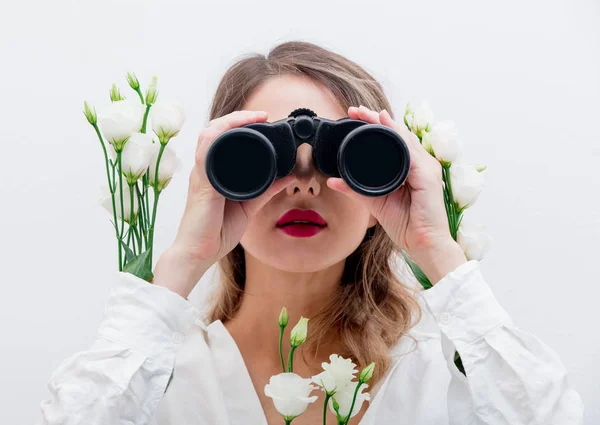 Beautiful woman with white roses in sleeves with binocular — Stock Photo, Image