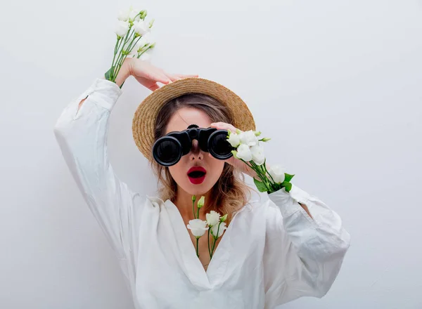 Mulher com rosas brancas nas mangas com binocular à procura de algo — Fotografia de Stock