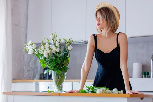 Ragazza vestita con un vestito nero vicino a bouquet di rose bianche in un vaso — Foto Stock