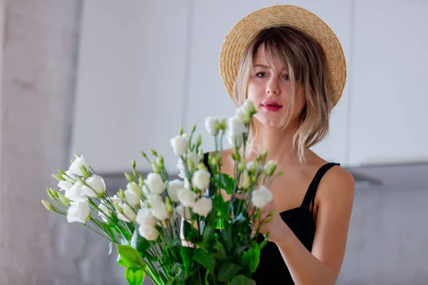 Ragazza vestita con un vestito nero vicino a bouquet di rose bianche in un vaso — Foto Stock