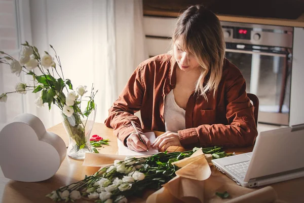 Businesswoman in modern clothes wrapping a white roses — Stock Photo, Image