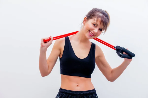 Adult girl in sport clothes with expander — Stock Photo, Image