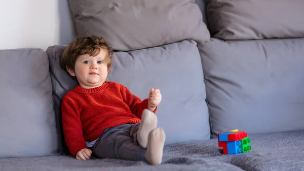 Drôle Petit Garçon Assis Sur Canapé Pull Rouge Vue Latérale — Photo