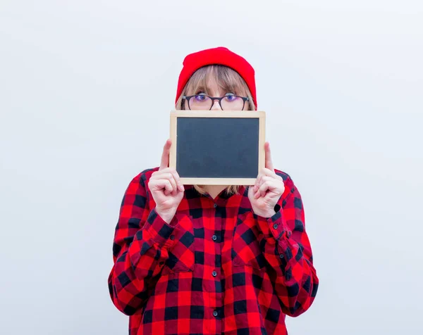 Junge Frau in rotem Hemd und Hut mit Tafel — Stockfoto