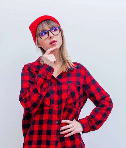 Młoda kobieta w czerwoną koszulę i kapelusz z okularami — Zdjęcie stockowe