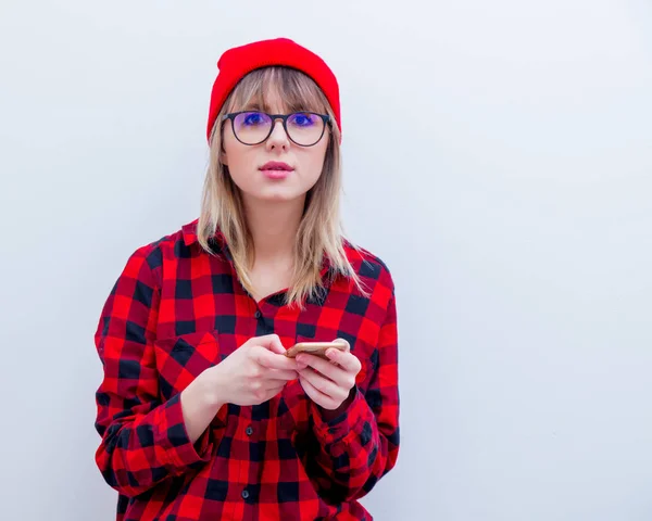 Junge Frau in rotem Hemd und Hut mit Handy — Stockfoto