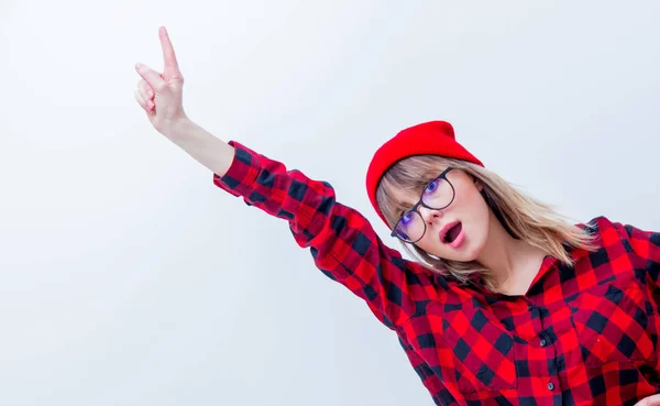 Kırmızı gömlek ve parmak ile işaret şapka genç kadın — Stok fotoğraf