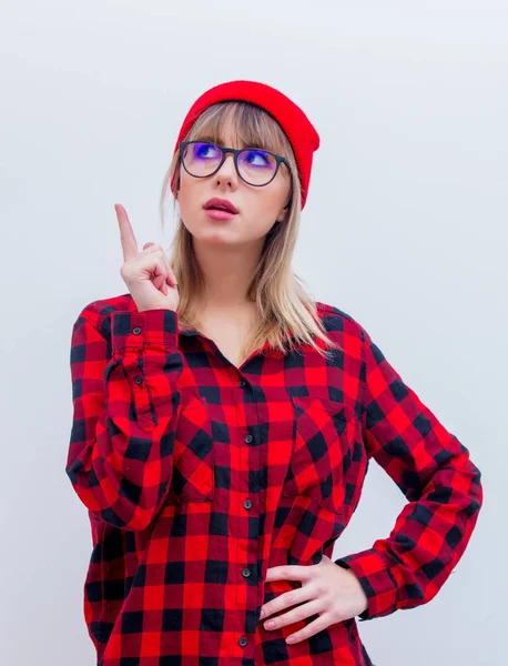 Jonge vrouw in een rood shirt en muts met bril — Stockfoto