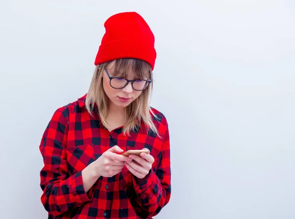 Junge Frau in rotem Hemd und Hut mit Handy — Stockfoto