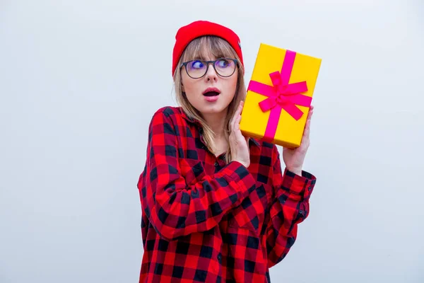 Mulher em camisa vermelha e chapéu segurando caixa de presente de férias — Fotografia de Stock