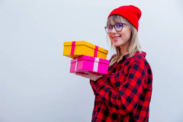 Kadın kırmızı bir gömlek ve tatil hediye kutuları tutarak şapka — Stok fotoğraf