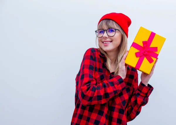 Mujer en camisa roja y sombrero sosteniendo caja de regalo de vacaciones — Foto de Stock