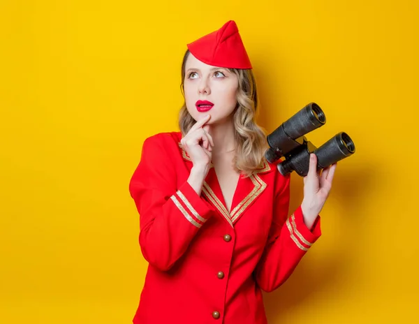 Charmante Vintage Stewardess in roter Uniform mit Fernglas — Stockfoto