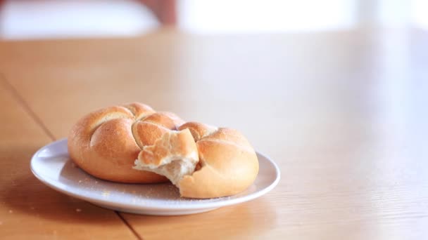 Kaiser roll on a plate on wooden table, — Stock Video