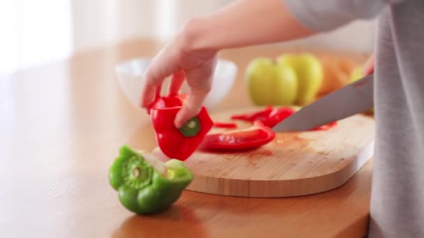 Vrouwelijke gesneden met een mes peper op keuken — Stockvideo