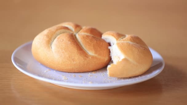 Kaiser roll on a plate on wooden table, — Free Stock Video