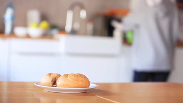 Kaiser roll on a plate on wooden table, — Stock Video