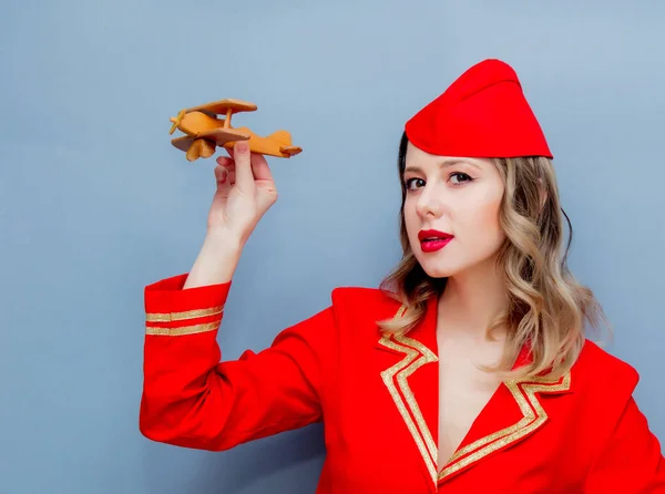 Porträt Einer Charmanten Stewardess Roter Uniform Mit Hölzernem Flugzeug Isoliert — Stockfoto