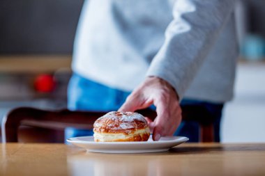 Genç adam bir masada bir çörek al