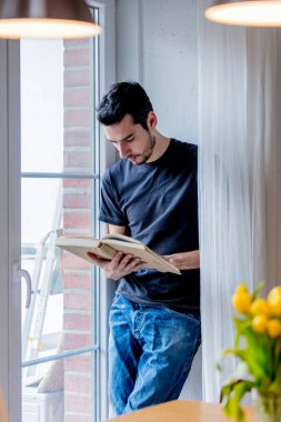 Pencere kalmak kitap ile genç adam