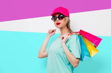 Kız alışveriş torbaları ile mavi t-shirt