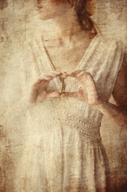 Eski anahtar bir elinde tutan kadın