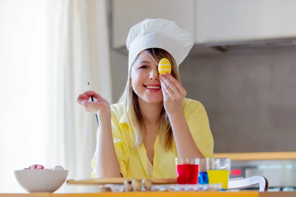 Жінка як шеф-кухарка малює яйця на Великдень — стокове фото
