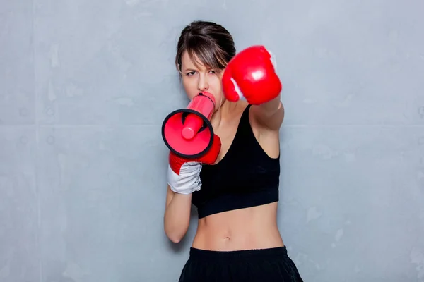 Jovem mulher em luvas de boxe com alto-falante — Fotografia de Stock