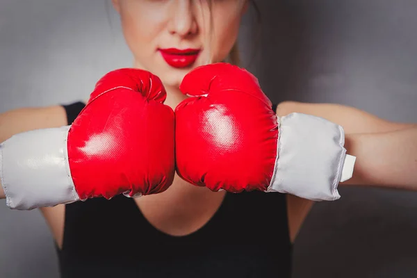 Kvinna i boxning handskar på grå bakgrund — Stockfoto