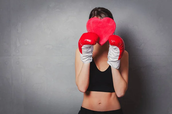 Donna in guantoni da boxe con forma di cuore confezione regalo in mano — Foto Stock