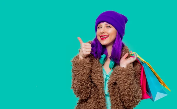 Chica con pelo morado en la chaqueta sosteniendo bolsas de compras —  Fotos de Stock