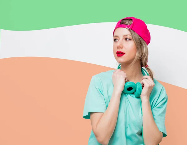 ピンクの帽子とヘッドフォンで青い t シャツの女の子 — ストック写真